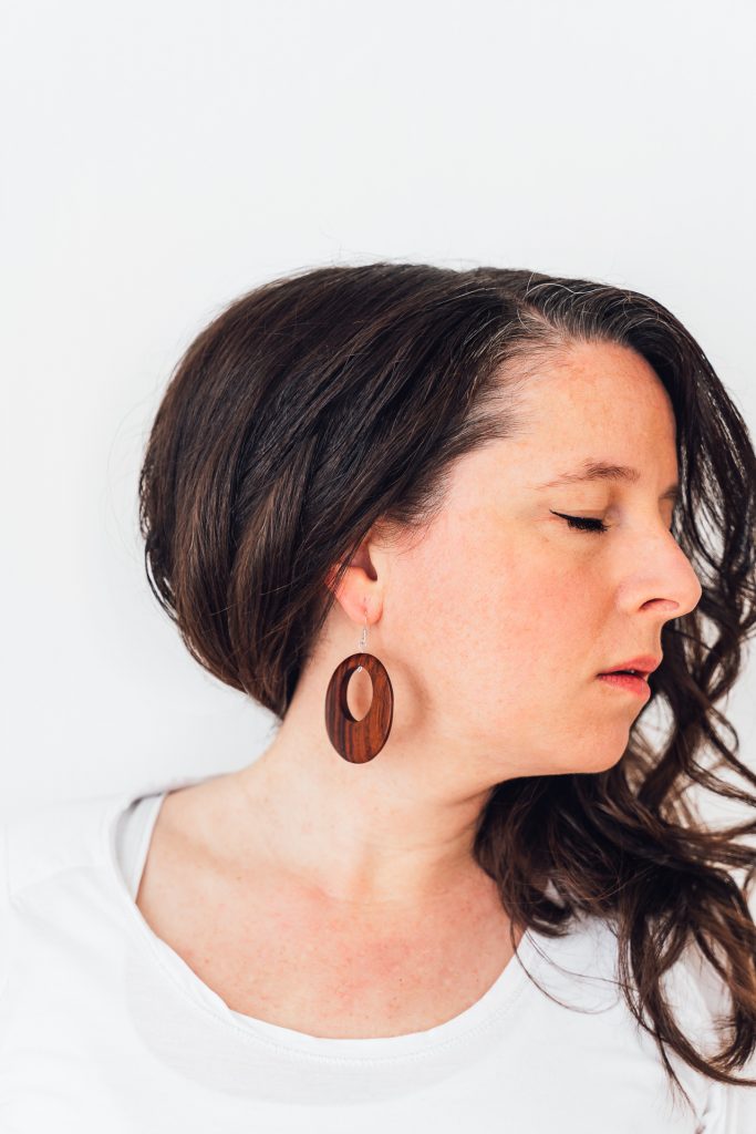 Selbstportrait Frau holz Ohrring weißer Hintergrund