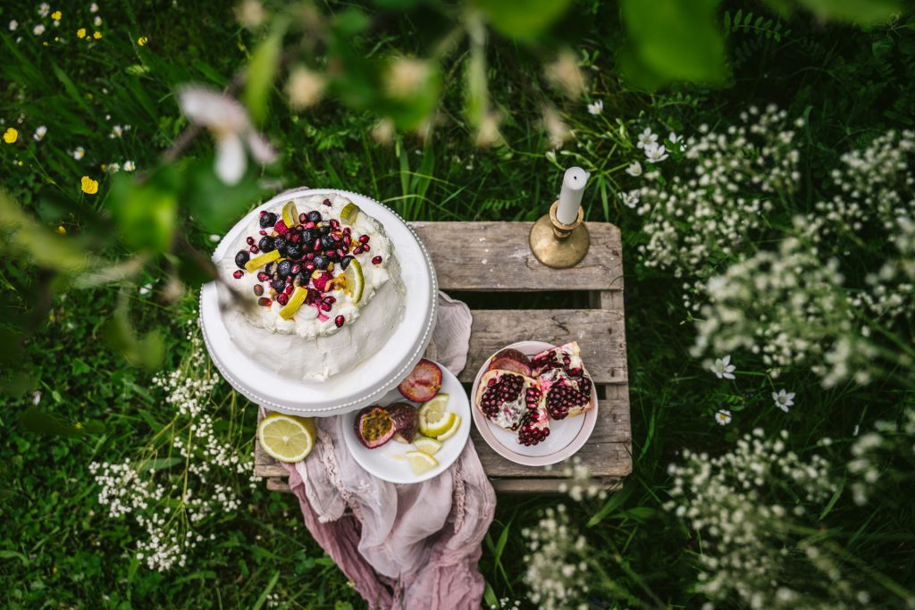 sommerliche Pavlova mit Früchten im Garten Food Fotografie granatapfel