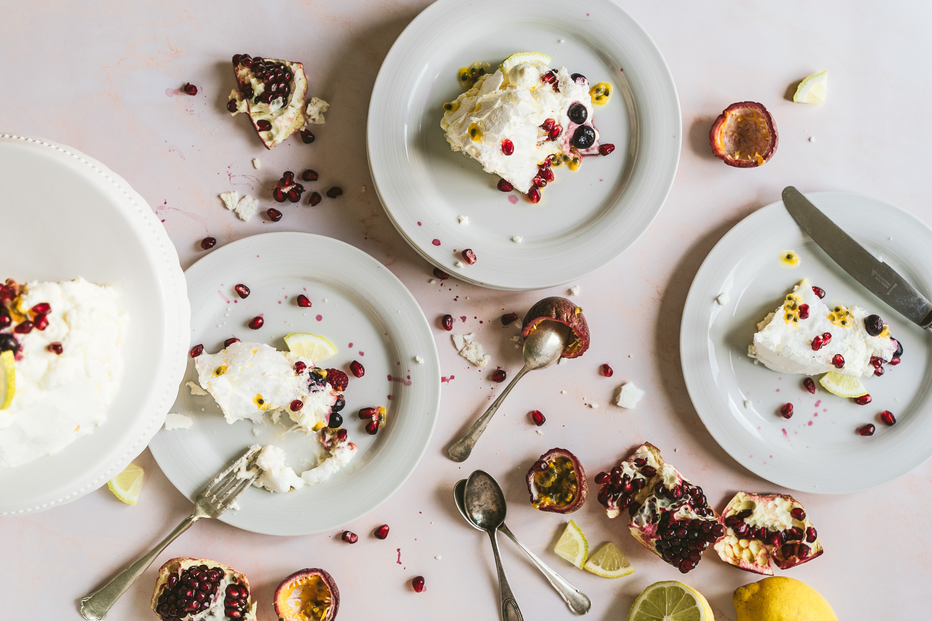 sommerliche Pavlova mit Früchten im Garten Food Fotografie granatapfel flatlay blumen