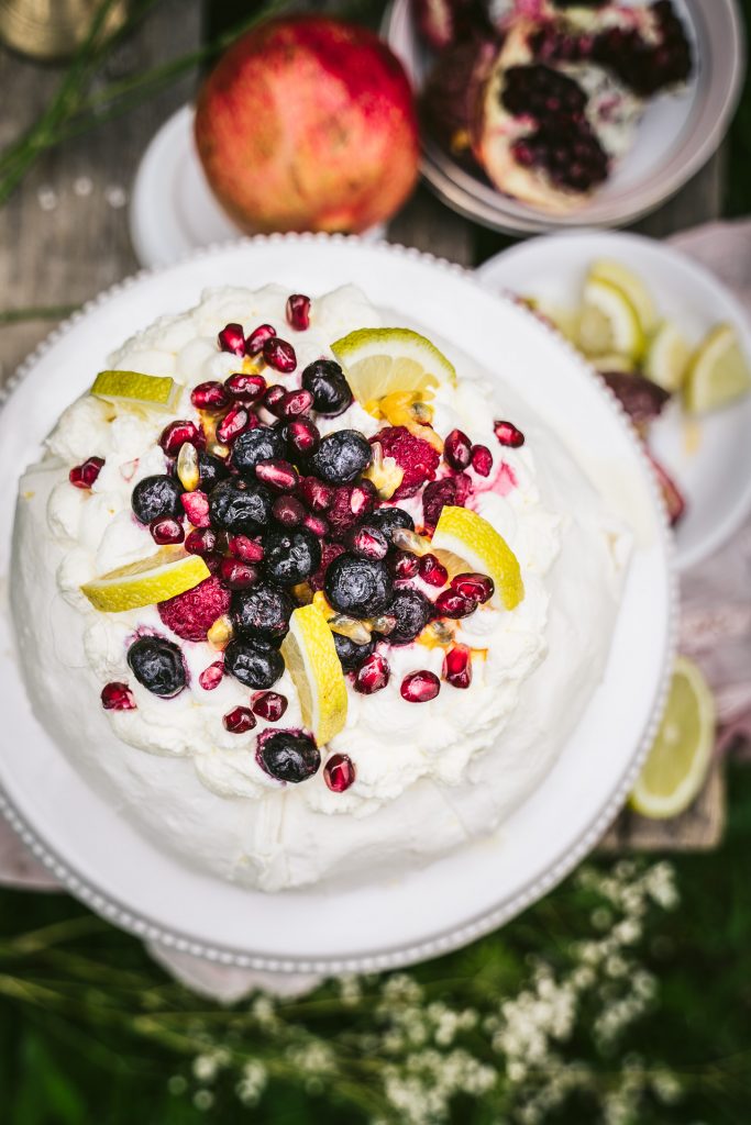 sommerliche Pavlova mit Früchten im Garten Food Fotografie granatapfel Apfelblüte blumen