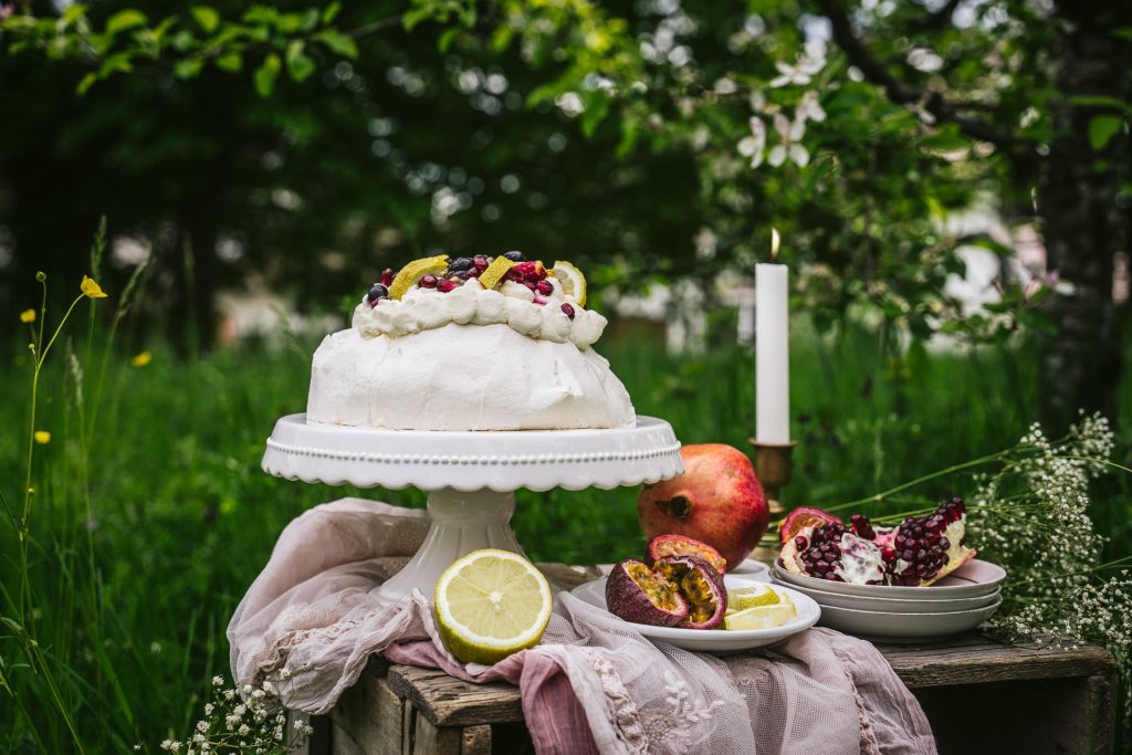 sommerliche Pavlova mit Früchten im Garten Food Fotografie granatapfel Apfelblüte blumen